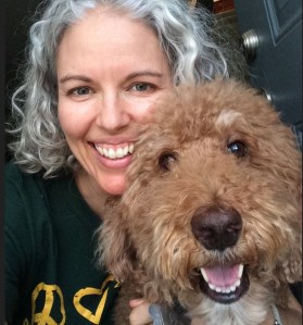 Stephanie and her furry friend, Malika, smiling at the camera.